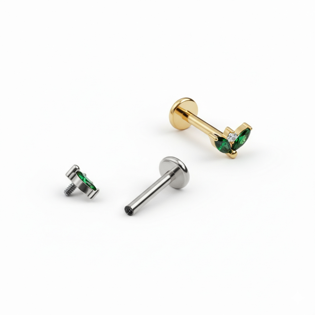 Tytanowy labret z parą szmaragdowych kamieni 